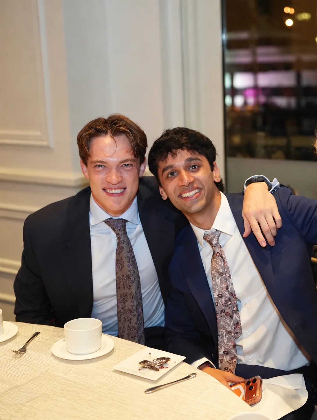Ash and Zac smiling together at a formal dinner